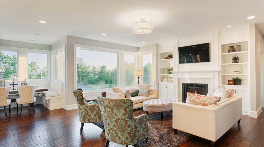 Bright, elegant living room with large windows and cozy seating.